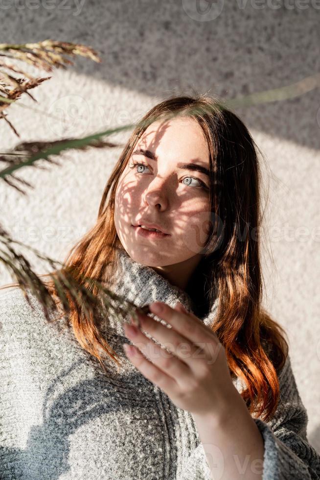 Porträt einer schönen jungen Frau mit einem Schattenmuster auf Gesicht und Körper in Form von Blumen foto