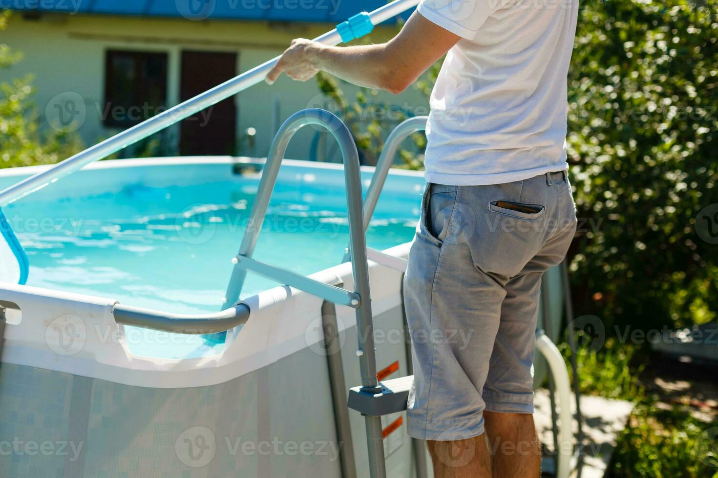 Mann Reinigung das Schwimmbad beim ihr Land Haus. Sommer- beim Zuhause Konzept. Lebensstil foto