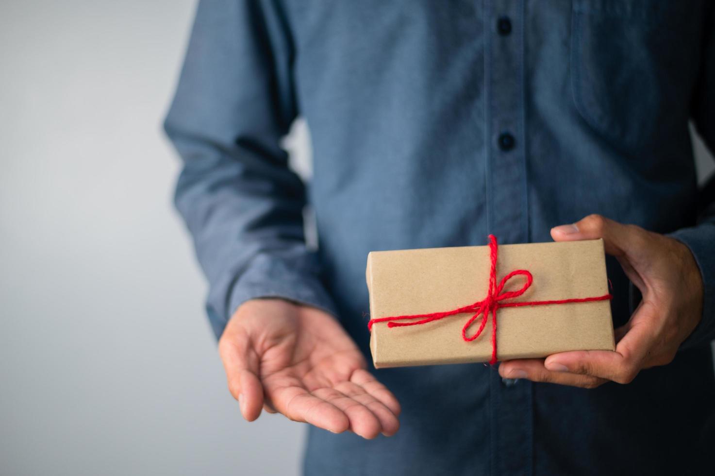 Hand, die Geschenkbox, Geschenkbox des neuen Jahres, Weihnachtsgeschenkbox, Kopienraum hält. Weihnachten, Jahr, Geburtstagskonzept. foto