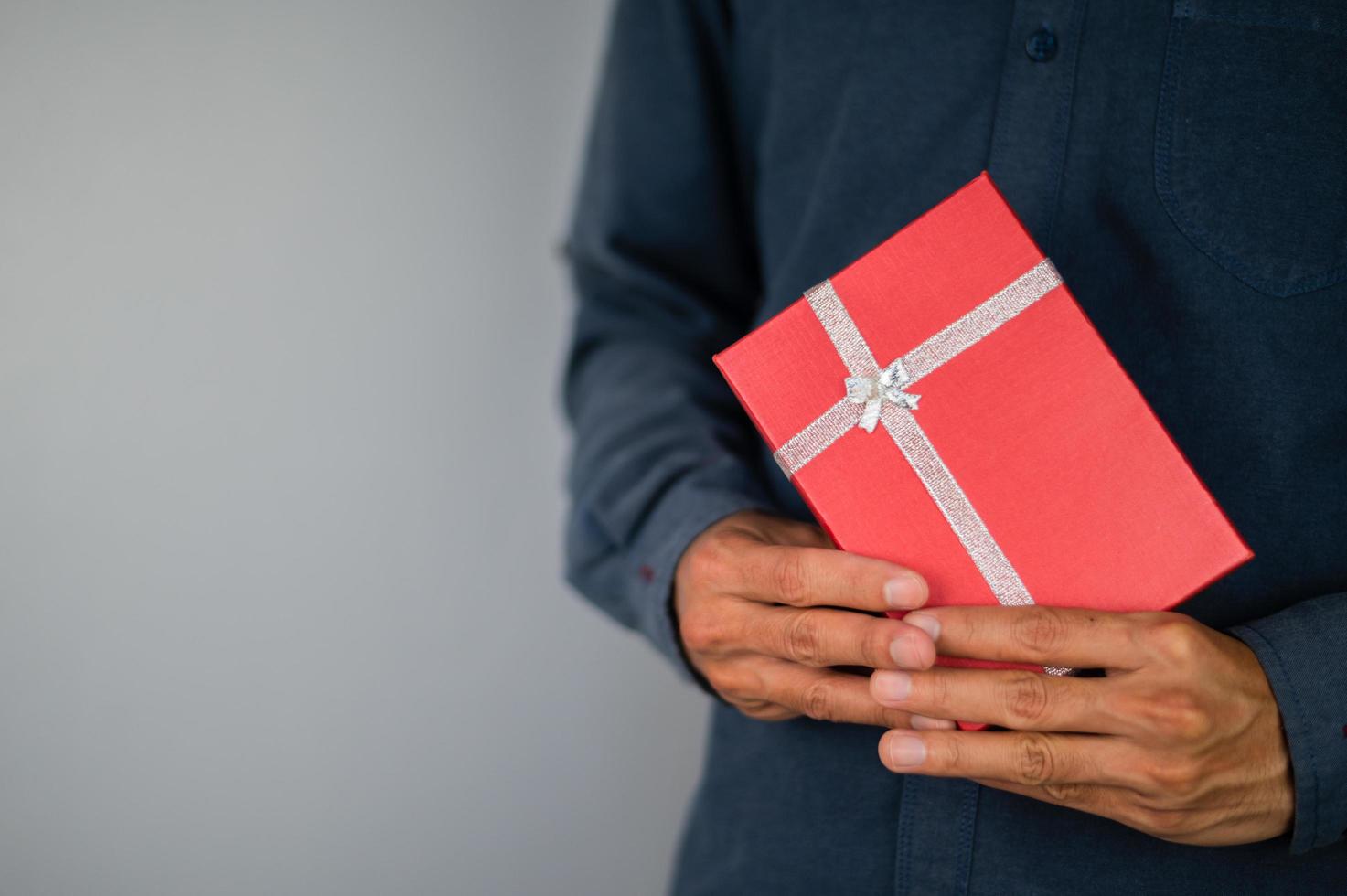 Hand, die Geschenkbox, Geschenkbox des neuen Jahres, Weihnachtsgeschenkbox, Kopienraum hält. Weihnachten, Jahr, Geburtstagskonzept. foto