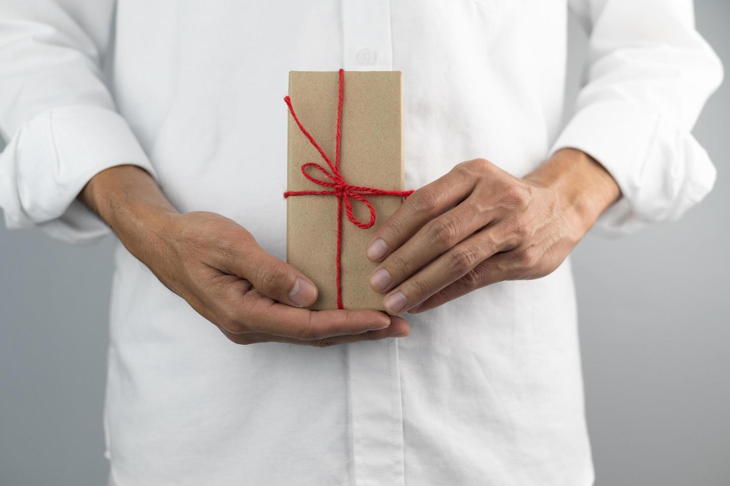 Hand, die Geschenkbox, Geschenkbox des neuen Jahres, Weihnachtsgeschenkbox, Kopienraum hält. Weihnachten, Jahr, Geburtstagskonzept. foto