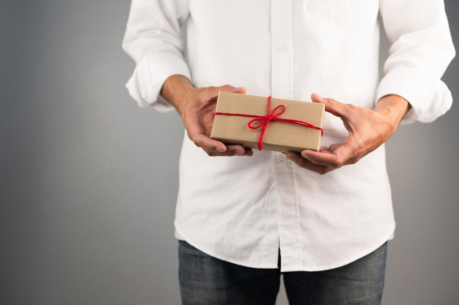 Hand, die Geschenkbox, Geschenkbox des neuen Jahres, Weihnachtsgeschenkbox, Kopienraum hält. Weihnachten, Jahr, Geburtstagskonzept. foto