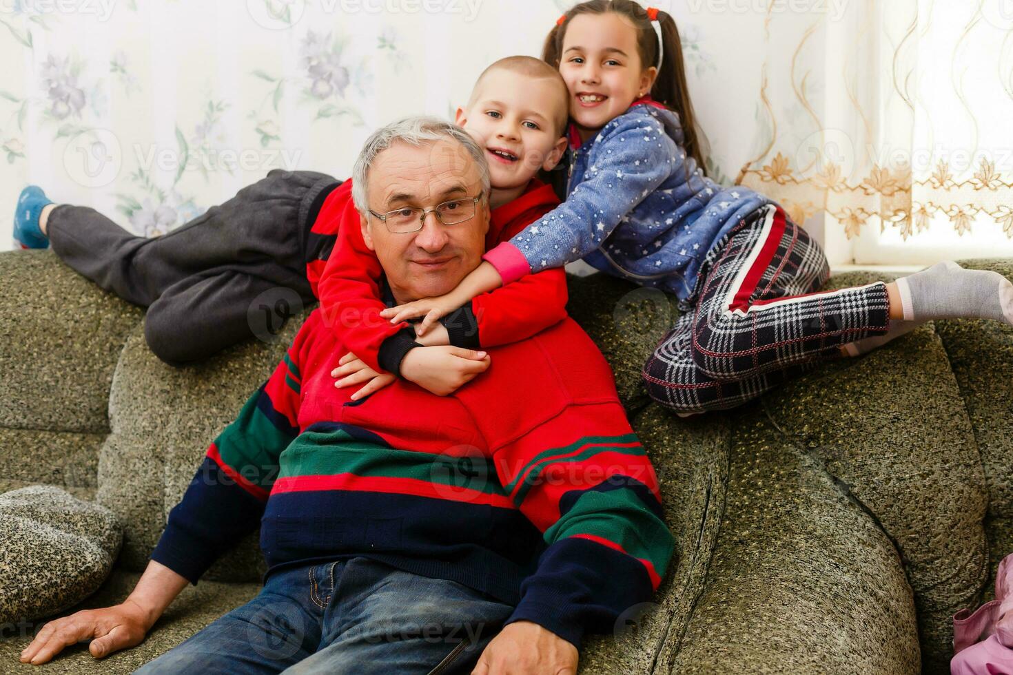 Großvater verbringt Zeit mit Enkelkinder im das Leben Zimmer foto