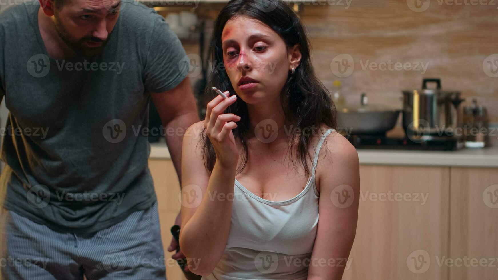 Porträt von missbraucht Ehefrau Rauchen im das Küche. missbraucht erschrocken geschlagen Frau bedeckt im Prellungen Leiden Verletzung von alkoholisch heftig brutal aggressiv Mann schreiend. foto