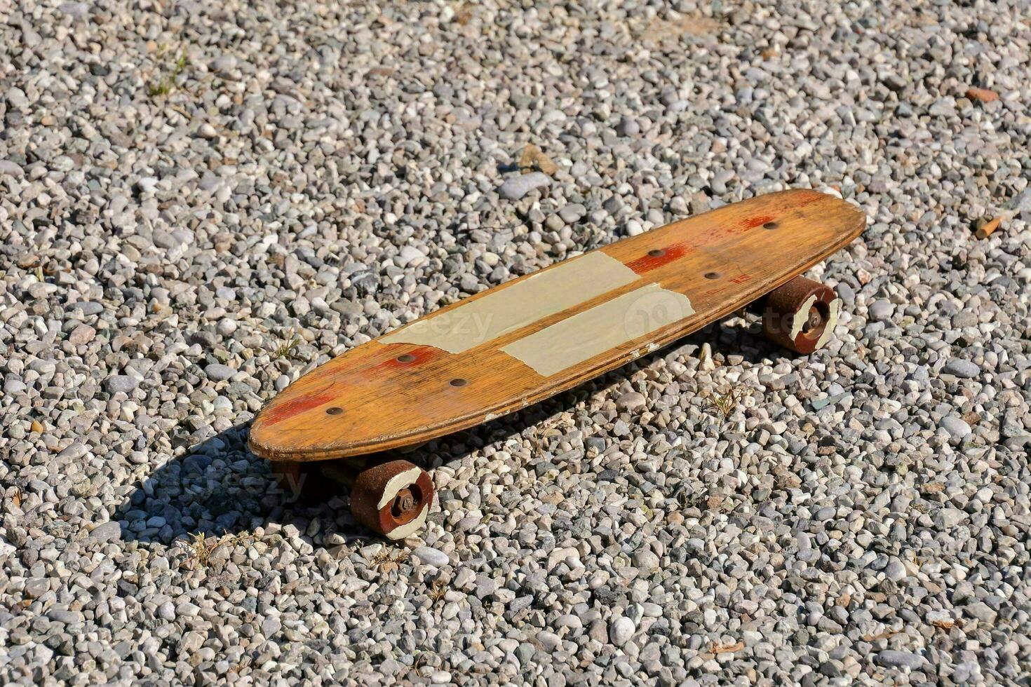 ein hölzern Skateboard auf Kies Boden foto