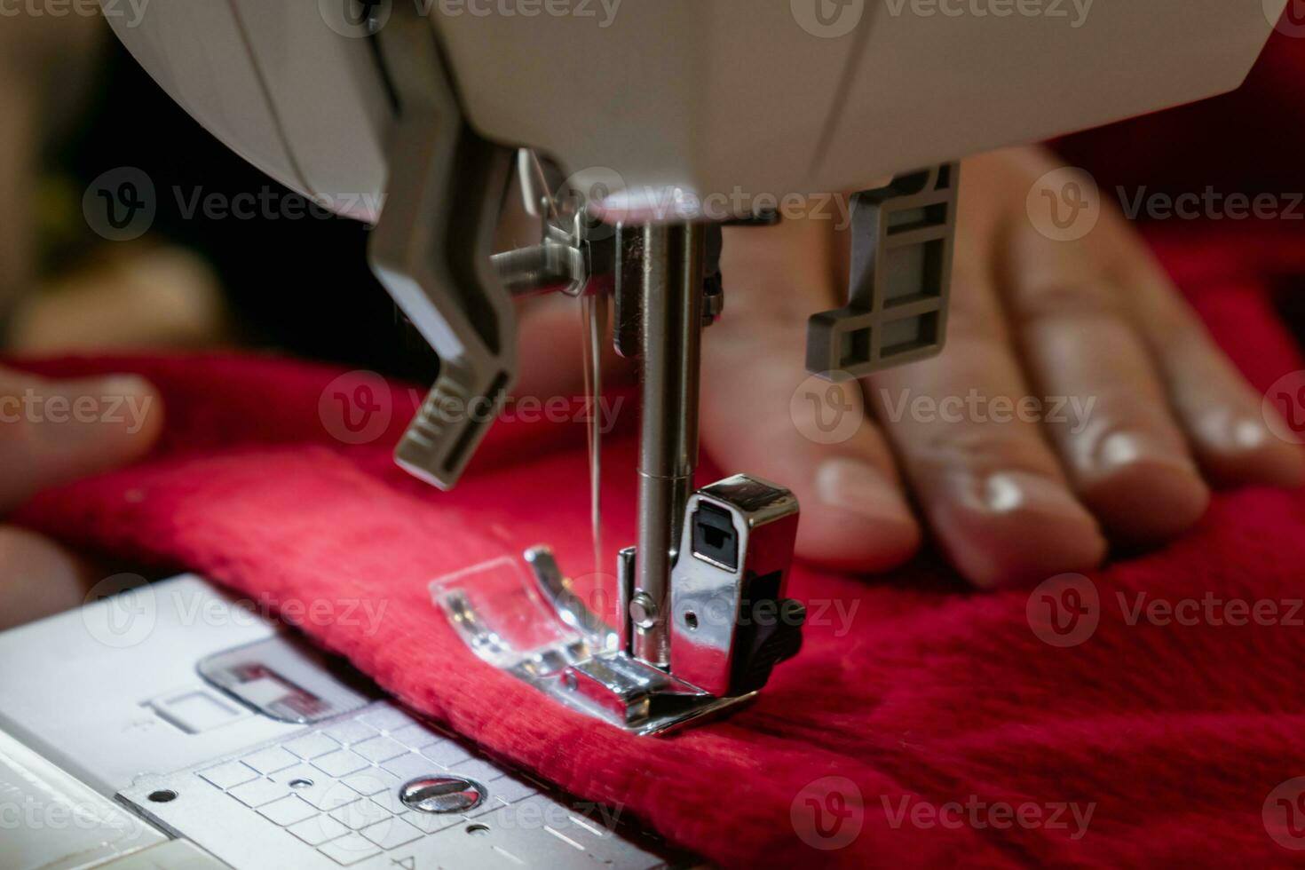 Mann mit ein Nähen Maschine mit ein rot Kleidungsstück, zum Reparatur arbeiten, Anpassung, Schaffung, Upcycling foto