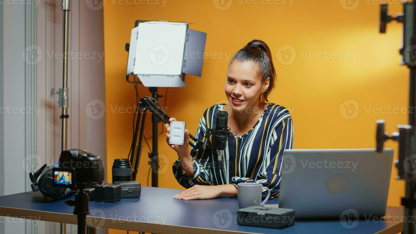 Sozial Medien Influencer tun ein Mini LED Licht Rezension im Fachmann Studio. Video Blogger Aufzeichnung ein vlog mit Technologie Produkt Ausrüstung verwenden im Videografie und Fotografie foto