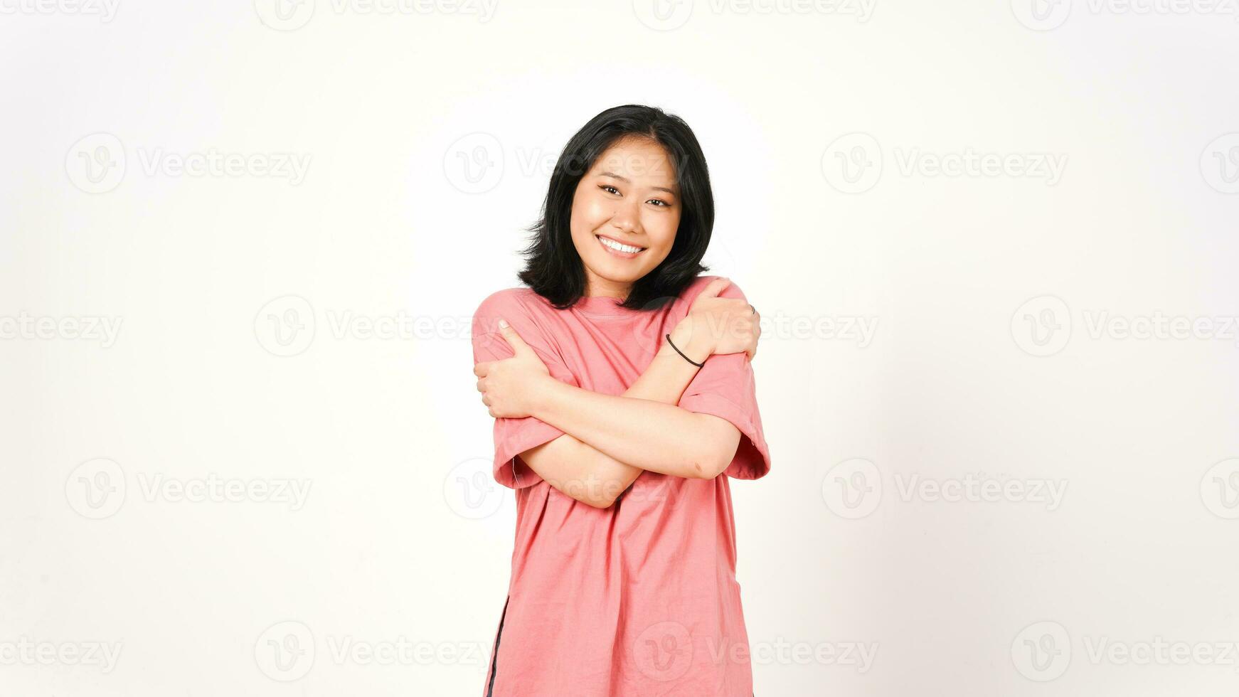 jung asiatisch Frau im Rosa T-Shirt Umarmung Sie selber selbst Liebe Konzept auf isoliert Weiß Hintergrund foto