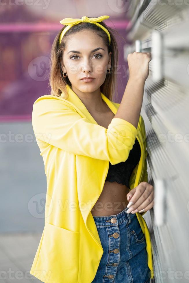 junge Frau mit gelber Jacke und Stirnband foto