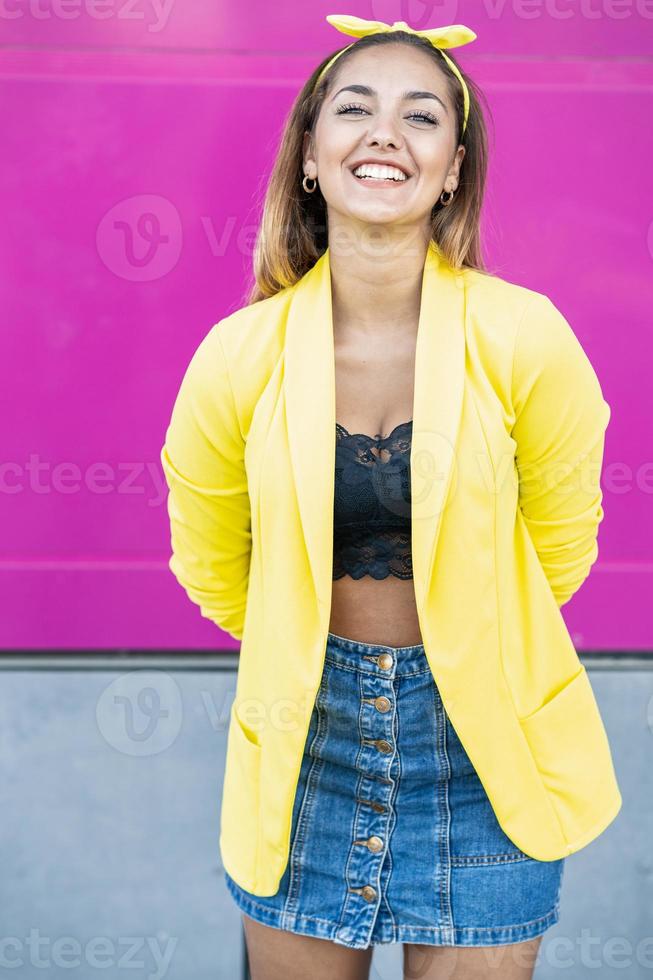 junge Frau mit gelber Jacke und Stirnband foto