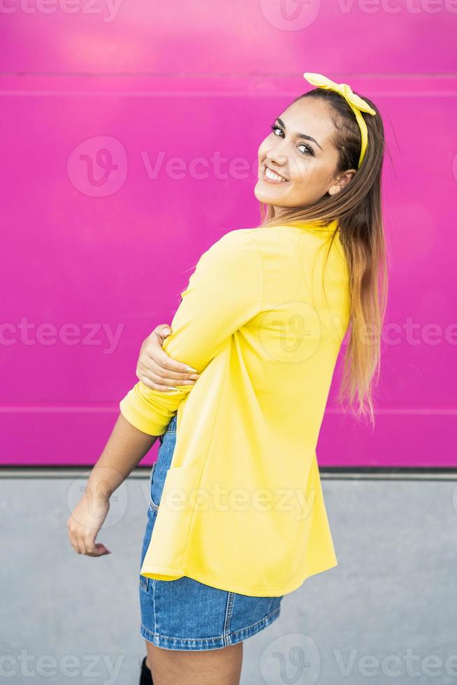 junge Frau mit gelber Jacke und Stirnband foto