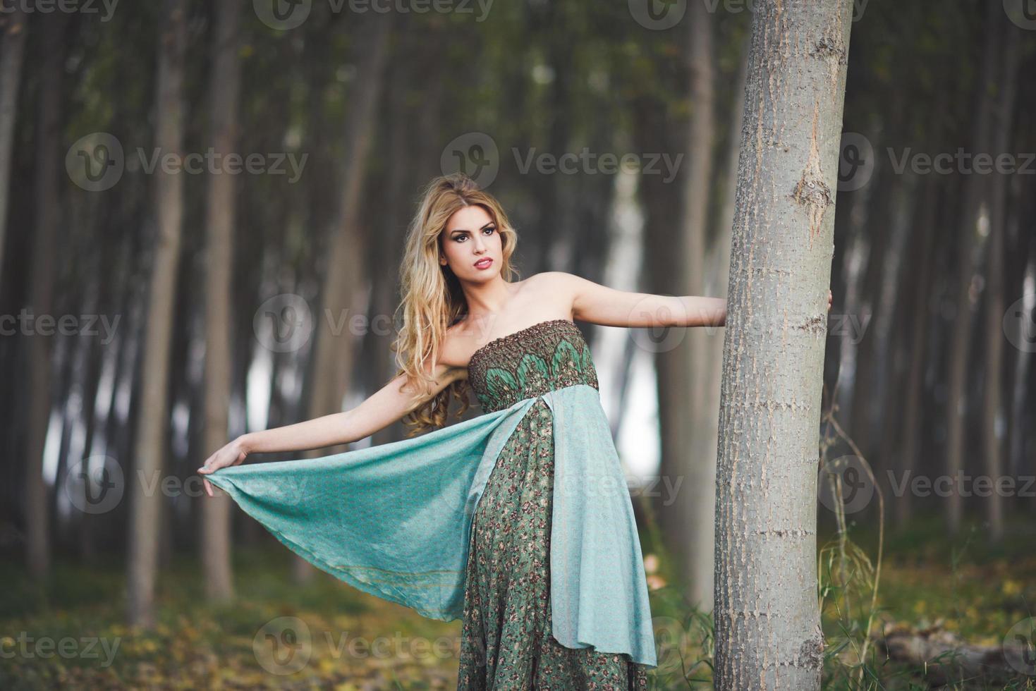 blonde Frau mit Vintage-Kleid in einem Pappelwald foto