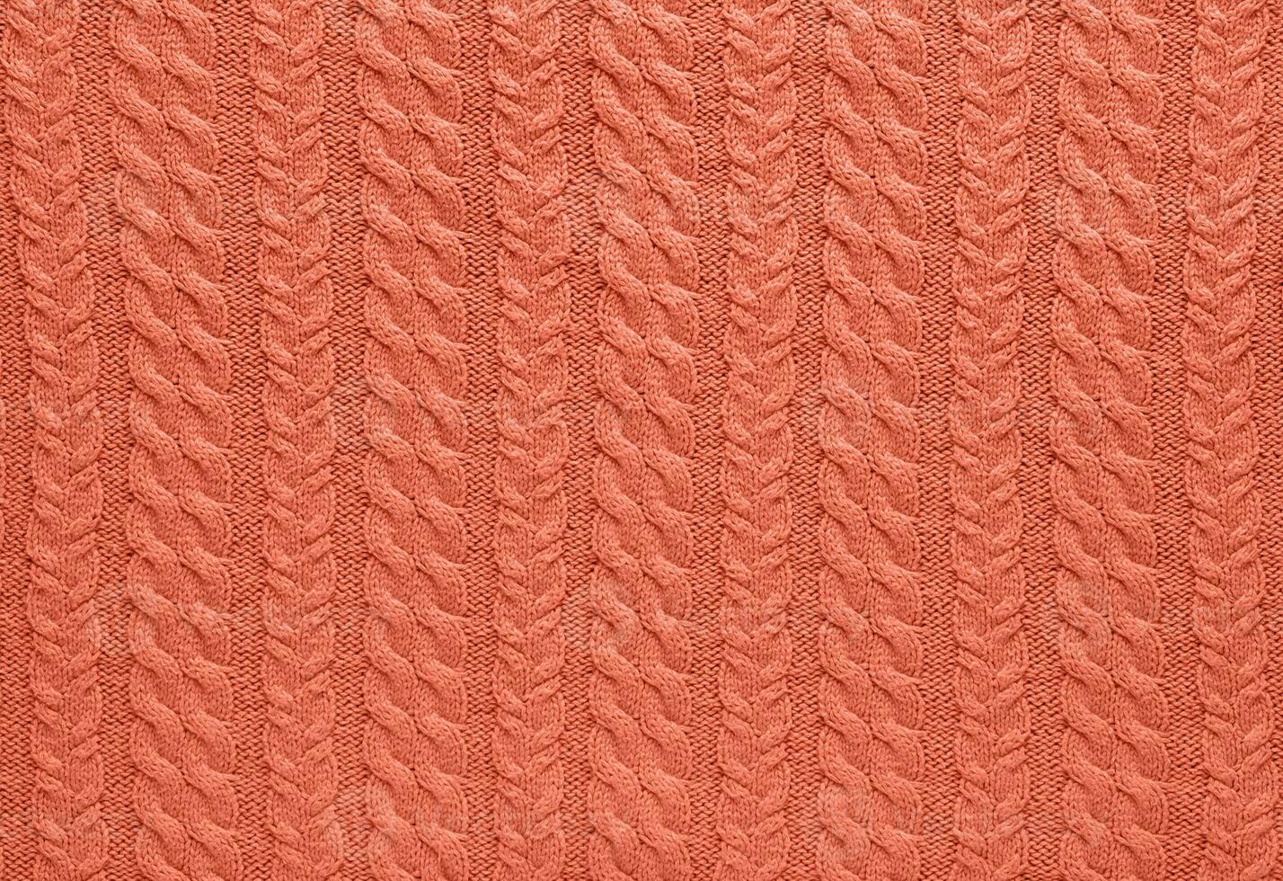 Textur von glatt gestrickt Sweatshirt mit Muster. handgemacht Stricken wolle oder Baumwolle Stoff Textur. Hintergrund von groß stricken Muster mit Stricken Nadeln oder häkeln. Pfirsich Flaum Farbe von 2024 Jahr foto
