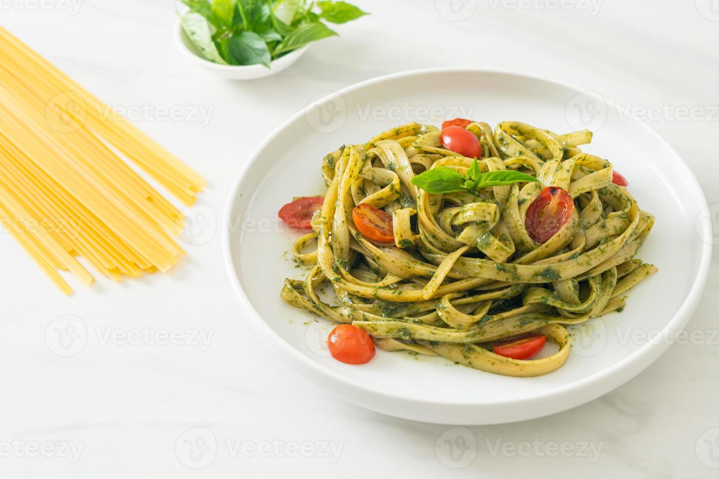 Fettuccine Spaghetti Pasta mit Pestosauce und Tomaten foto