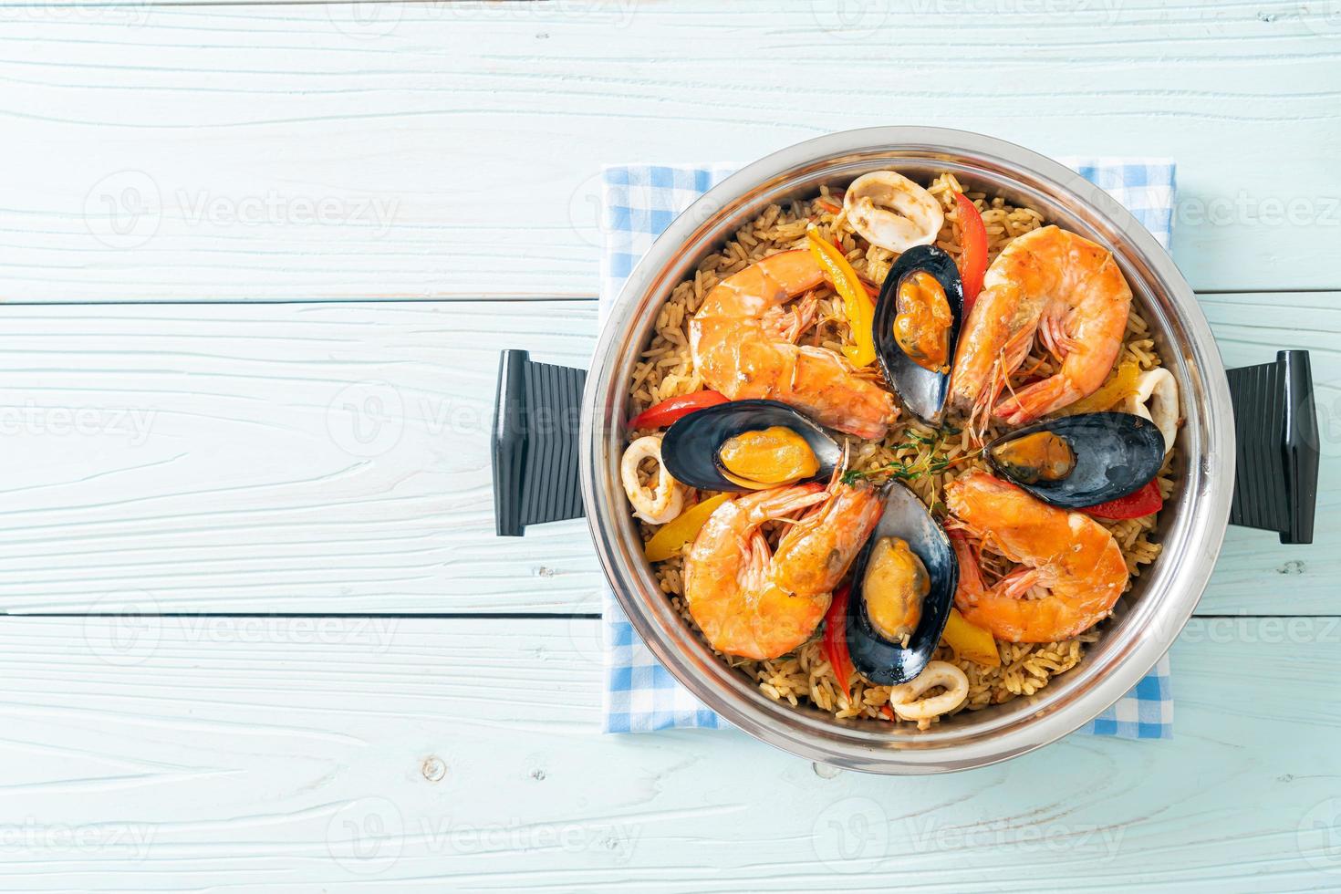 Meeresfrüchte-Paella mit Garnelen, Venusmuscheln, Miesmuscheln auf Safranreis foto