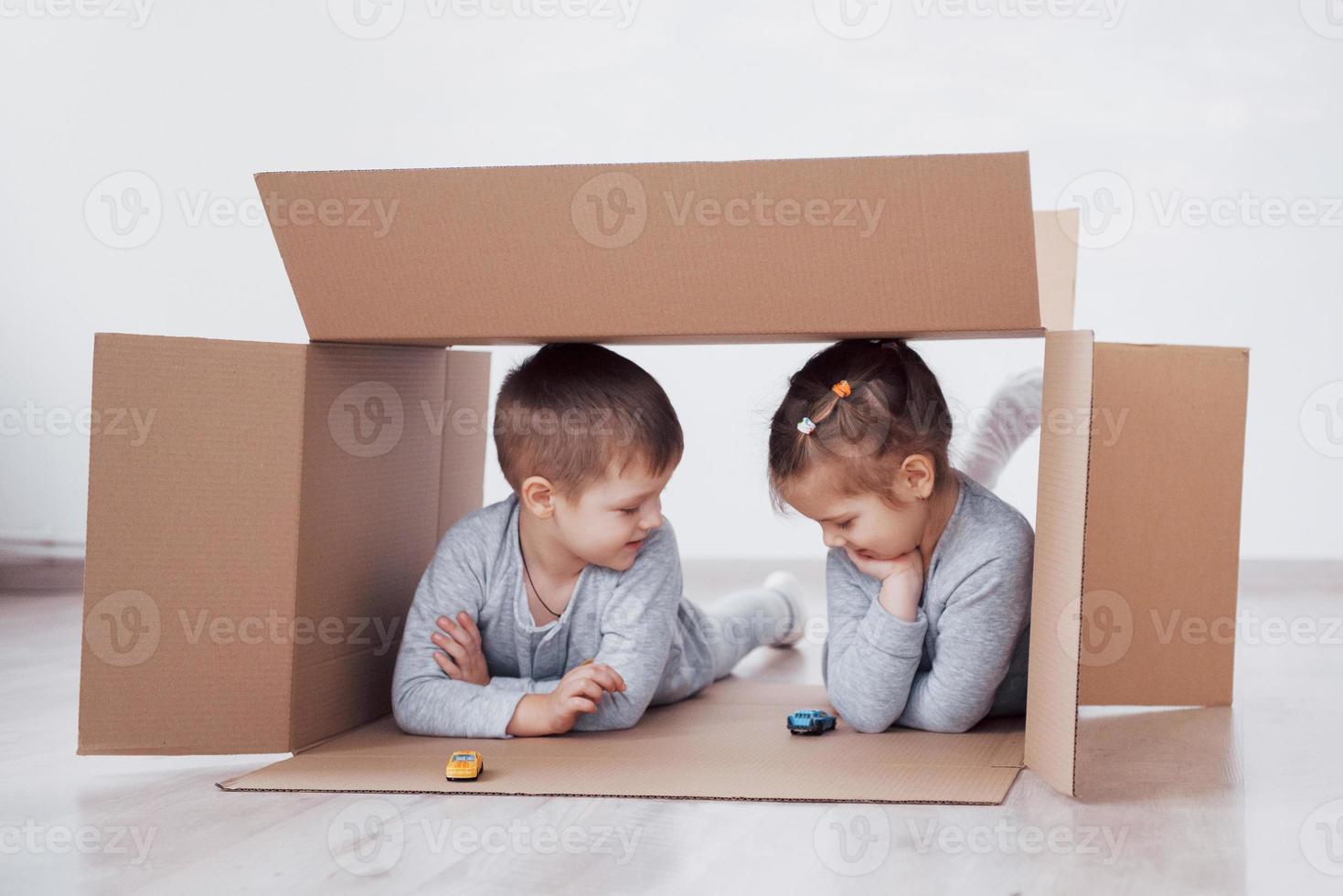 zwei kleine Kinder, Junge und Mädchen, sind gerade in ein neues Zuhause gezogen. Konzeptfoto .. Kinder haben Spaß. foto