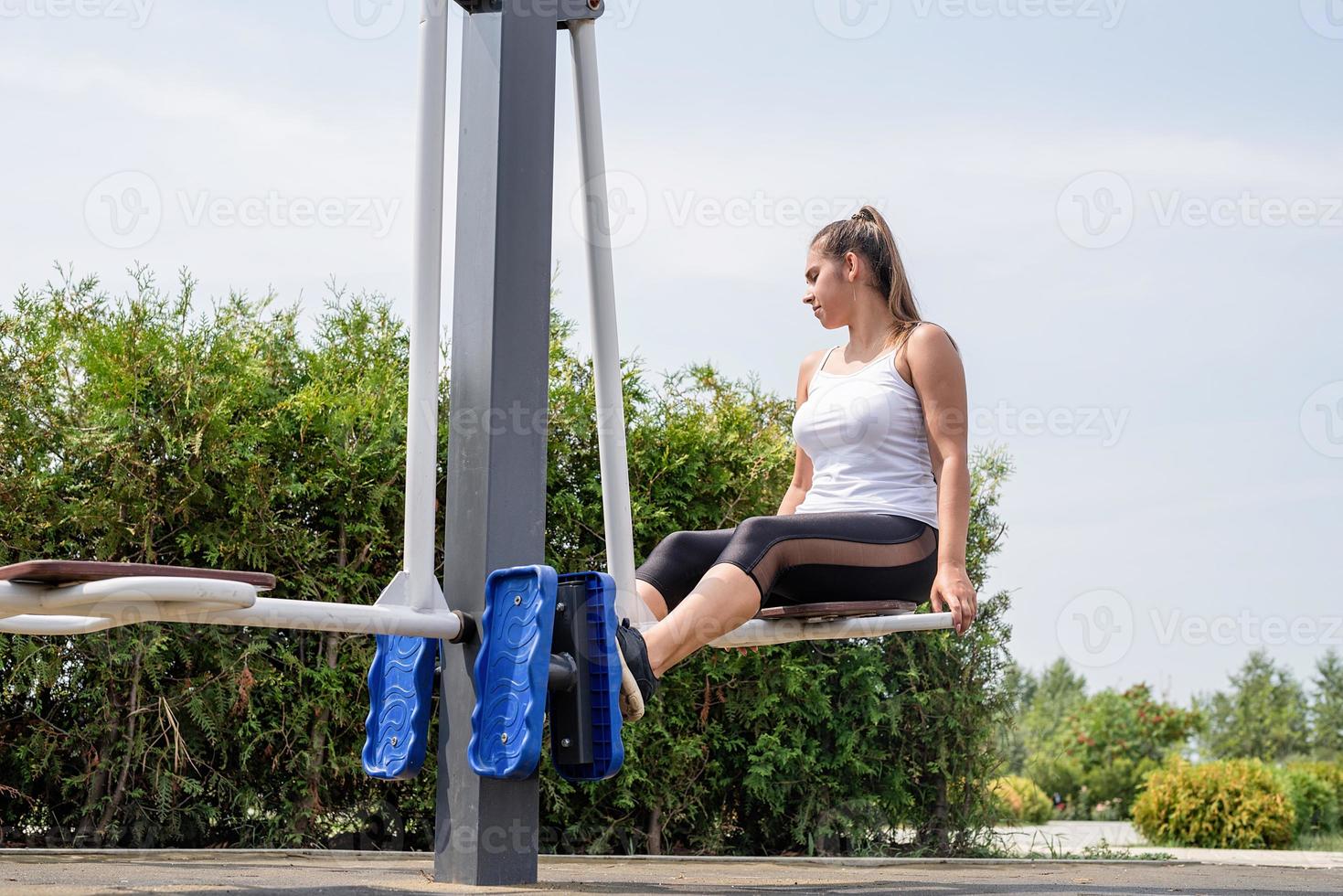 glückliche Frau, die am sonnigen Sommertag auf dem Sportplatz trainiert foto