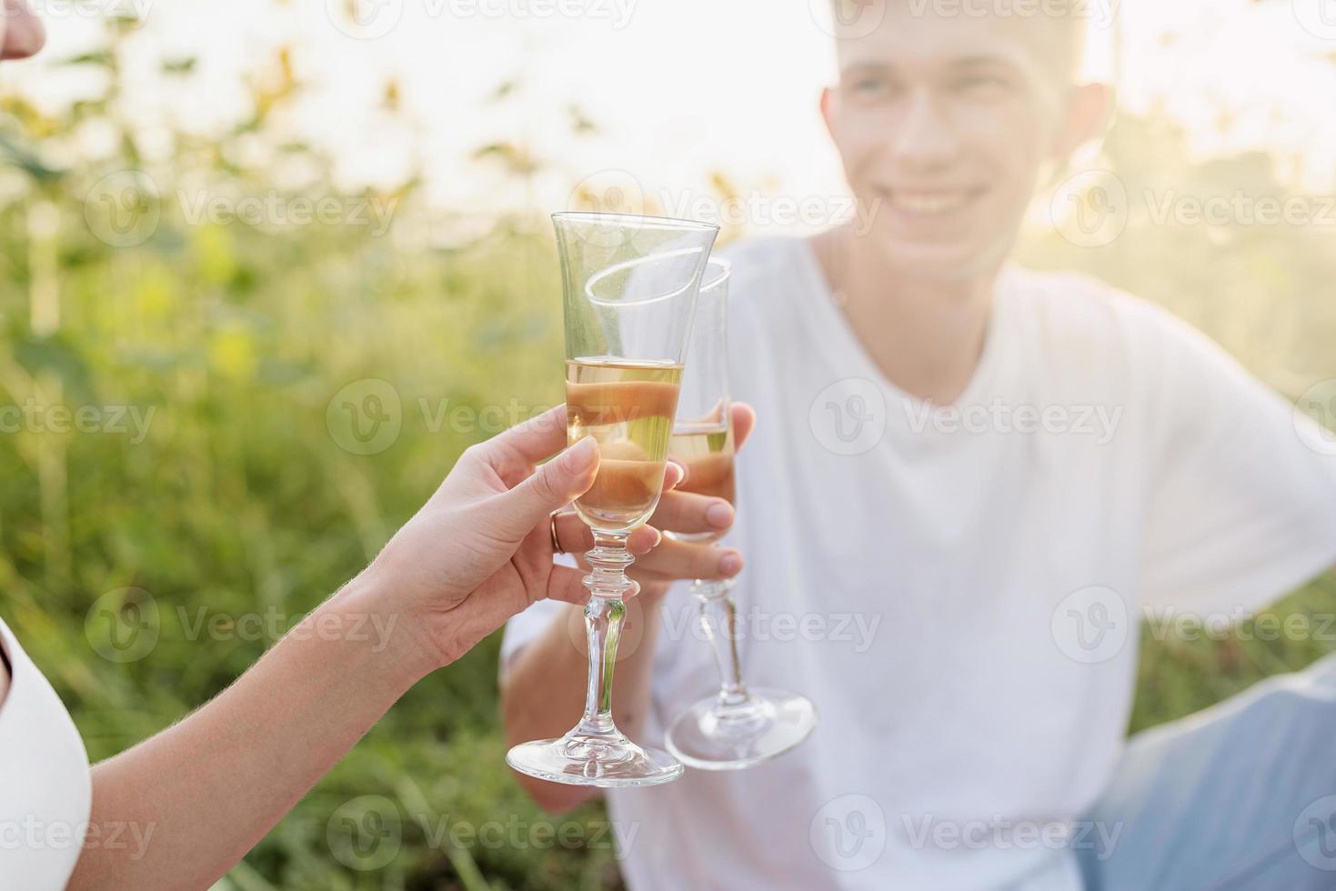 junges Paar beim Picknick auf Sonnenblumenfeld bei Sonnenuntergang foto