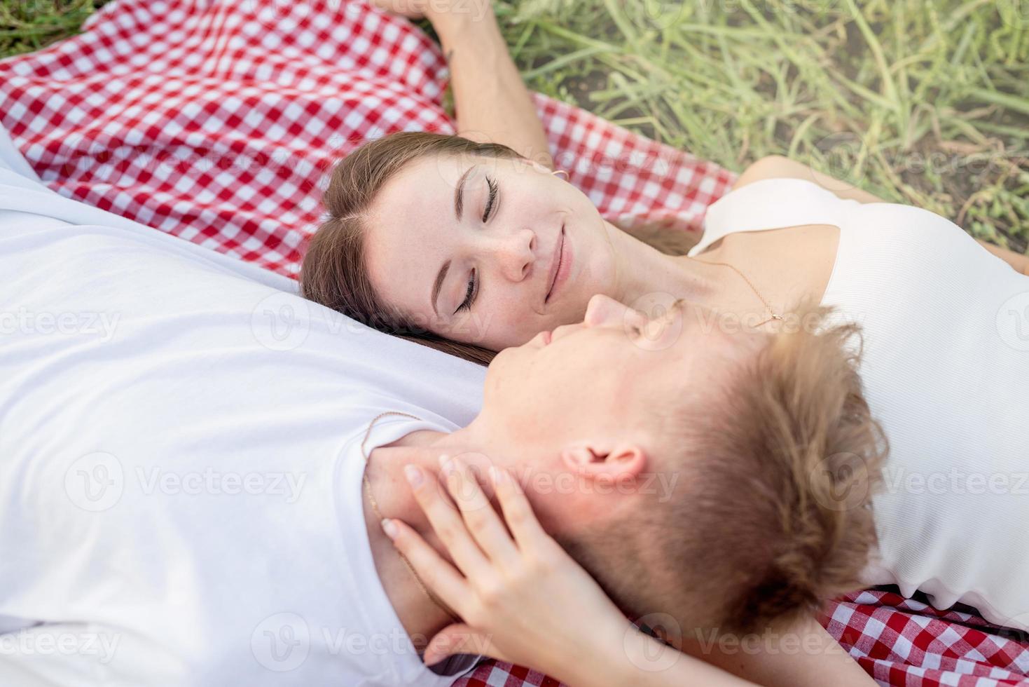 junges Paar kuschelt auf einer Picknickdecke foto