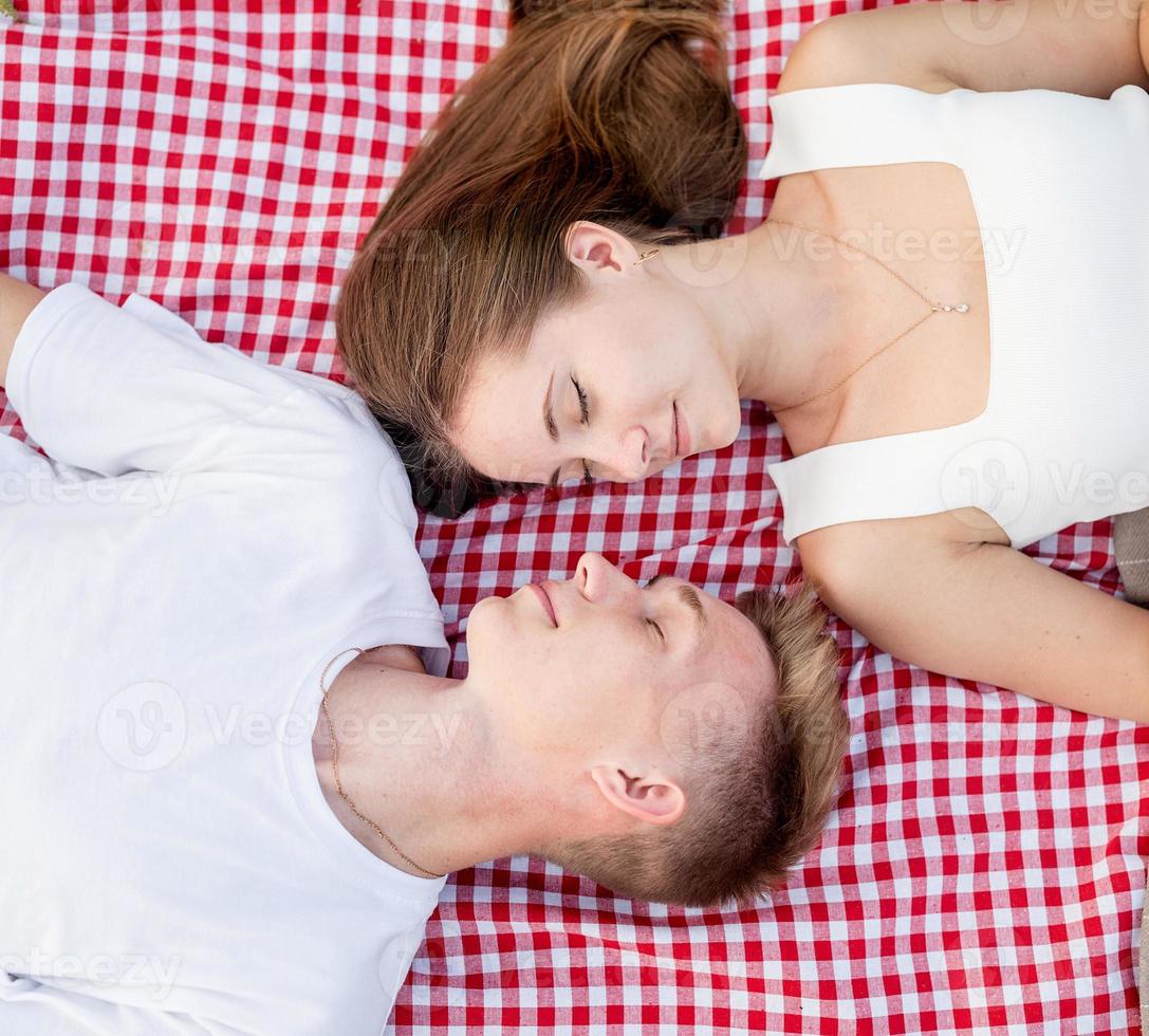 junges Paar kuschelt auf einer Picknickdecke, Ansicht von oben foto