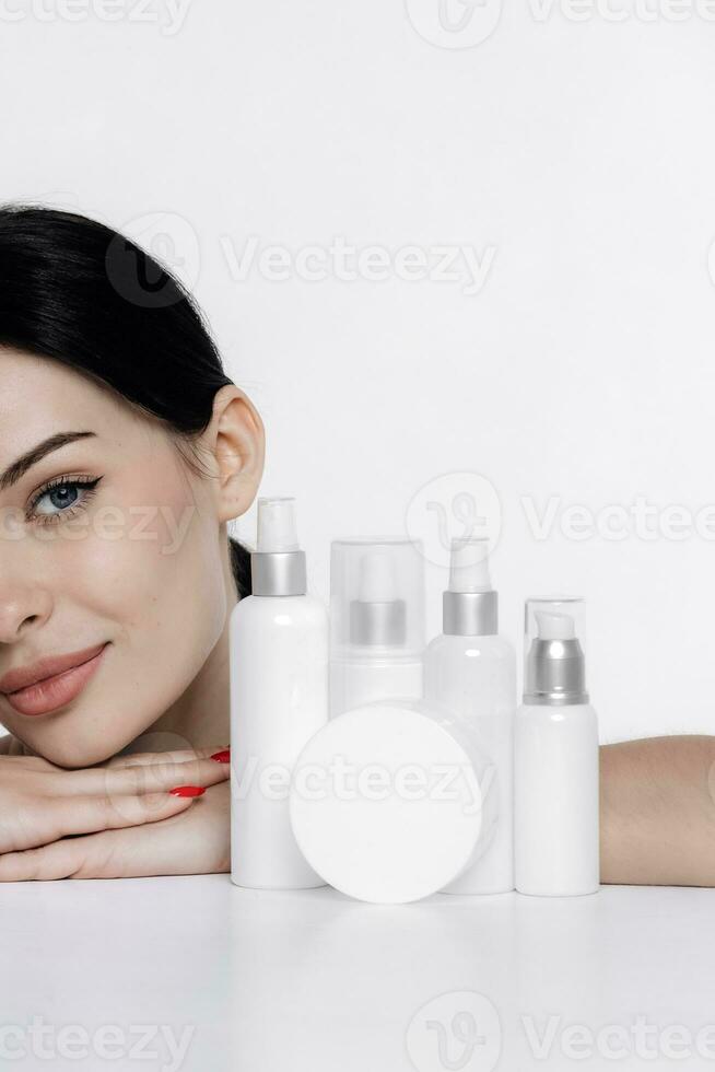 Frau zeigen kosmetisch Produkte branding Attrappe, Lehrmodell, Simulation. Täglich Hautpflege und Körper Pflege Routine. natürlich kosmetisch Creme, Serum, Weiß Flaschen Verpackung, bio organisch Produkt. foto