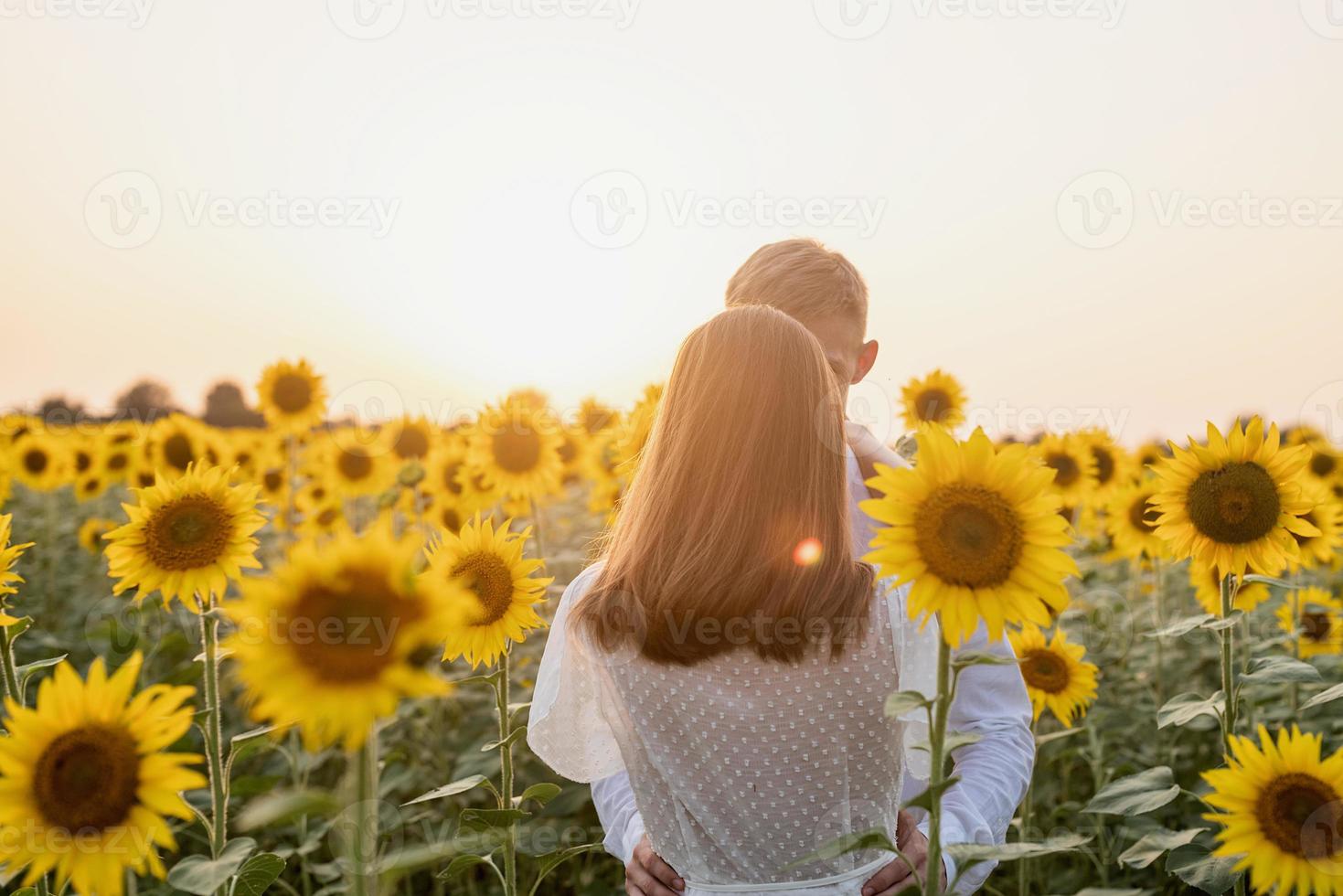 schönes paar, das spaß in sonnenblumenfeldern hat foto