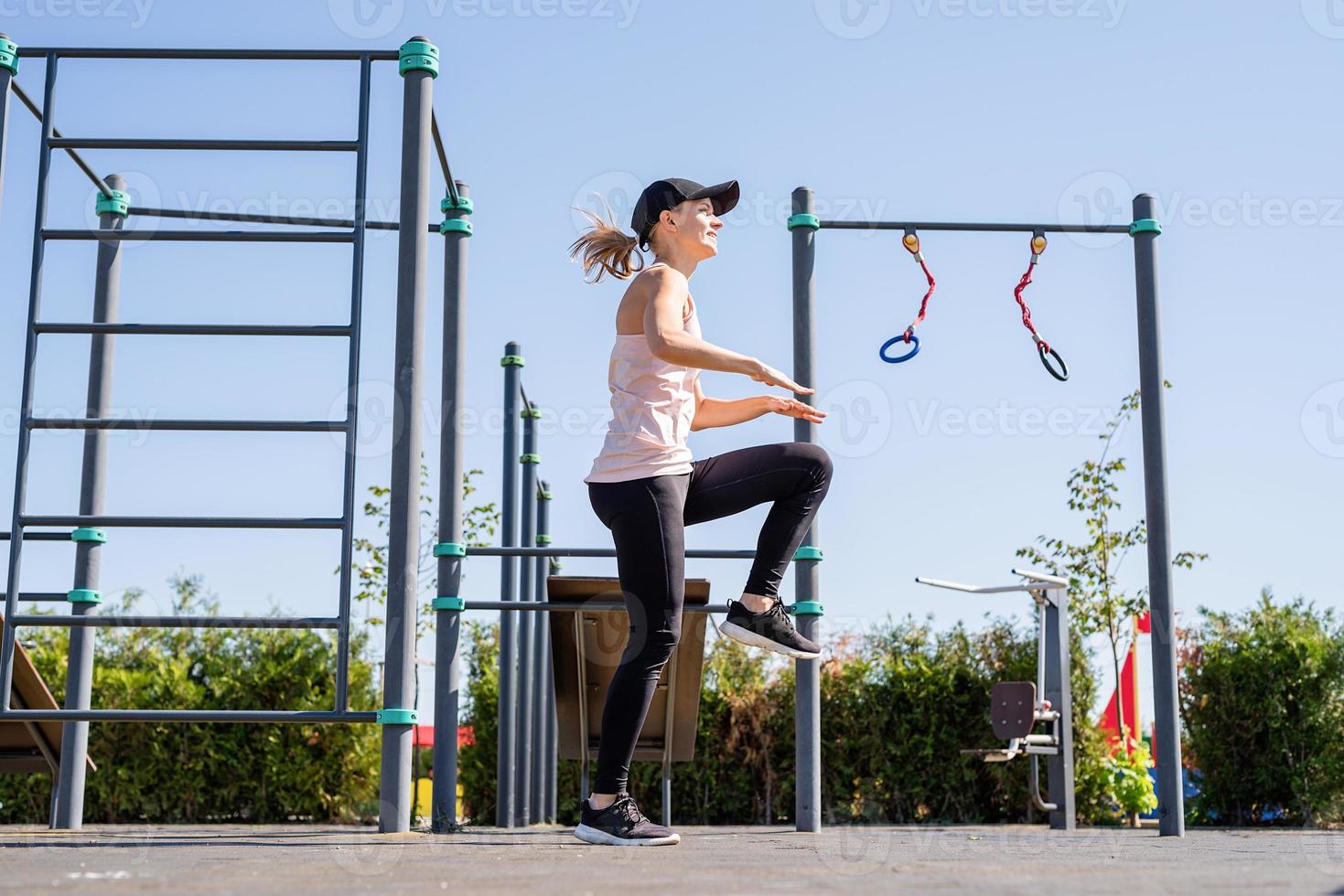 sportliche Frau, die an sonnigen Sommertagen auf dem Sportplatz trainiert foto