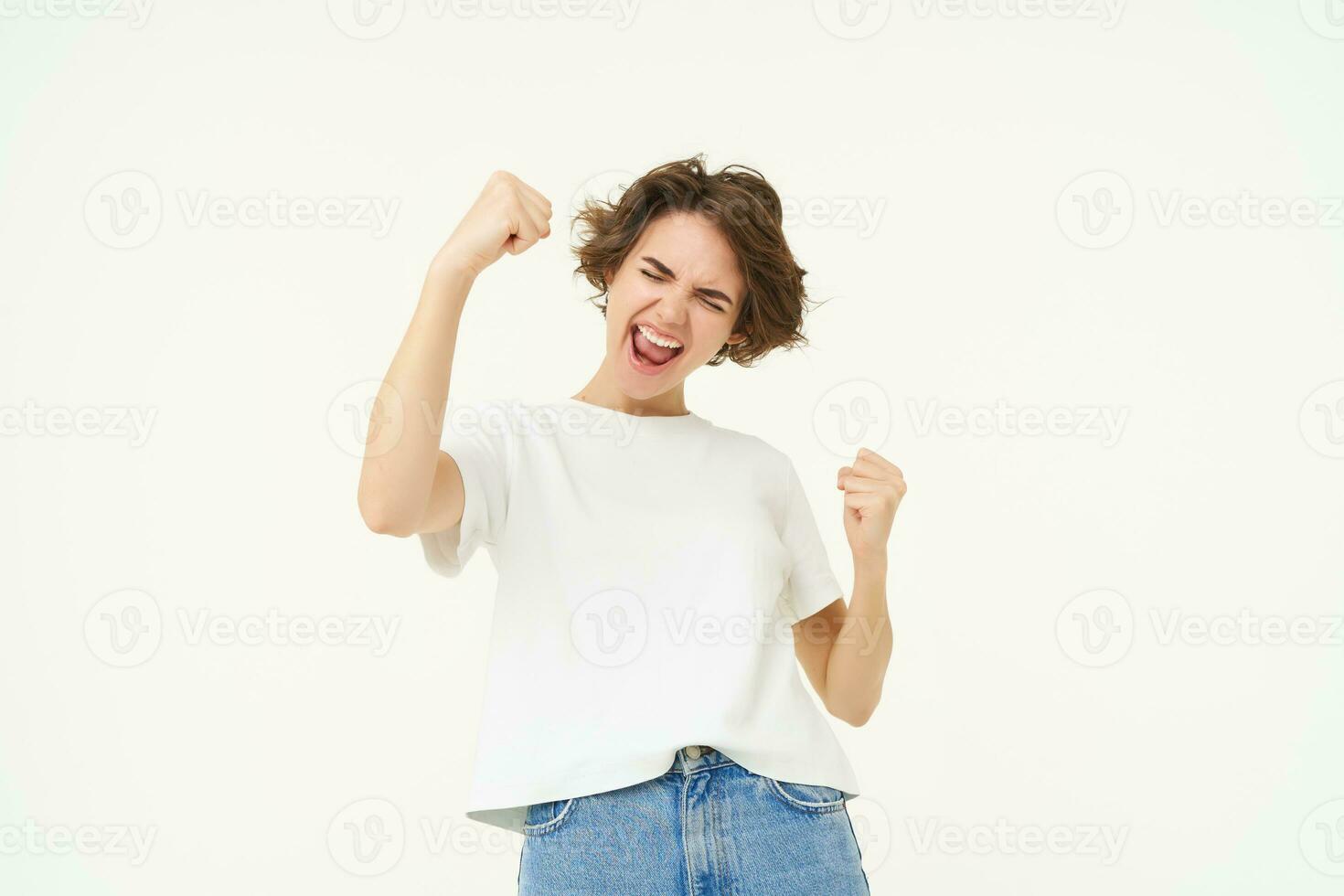 heiter Brünette Frau gewinnen, triumphierend, feiern Sieg, erreicht Ziel, steht Über Weiß Hintergrund foto