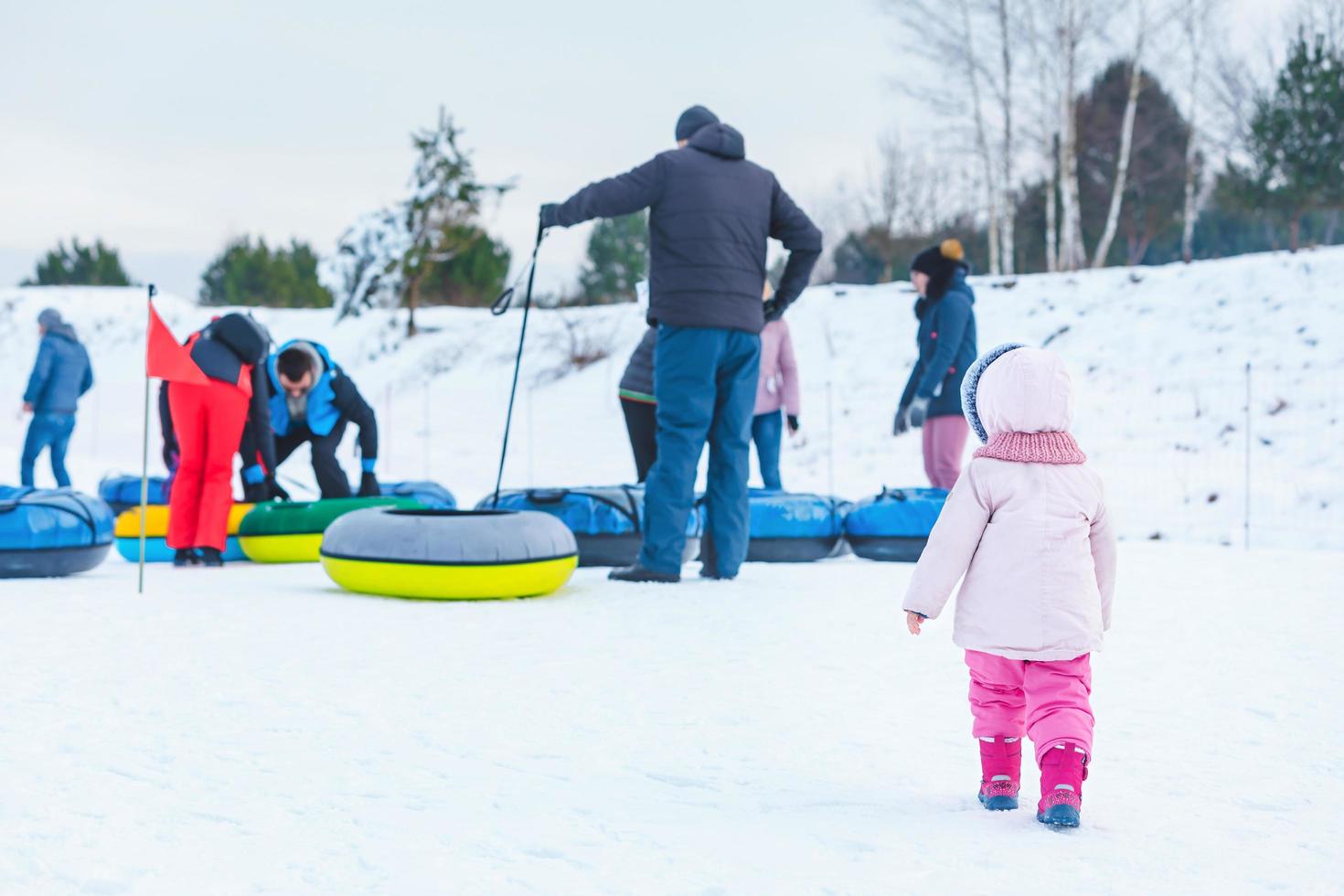 Leute, die im Winterpark Snowtubing fahren foto