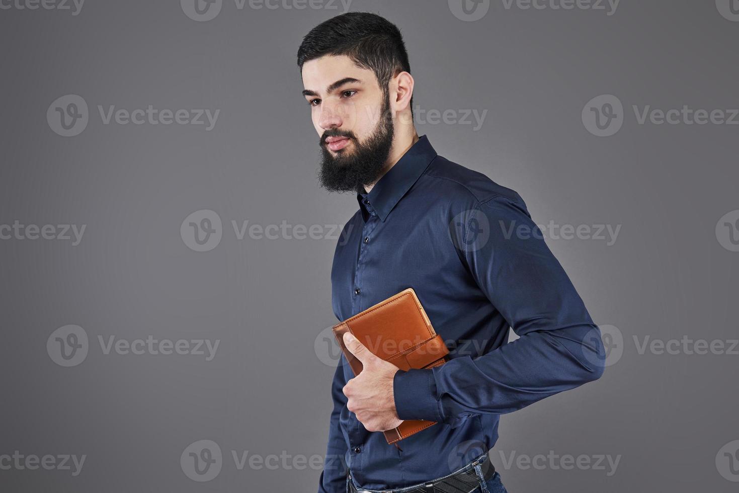 Porträt eines gutaussehenden bärtigen Mannes mit Buch auf Händen foto