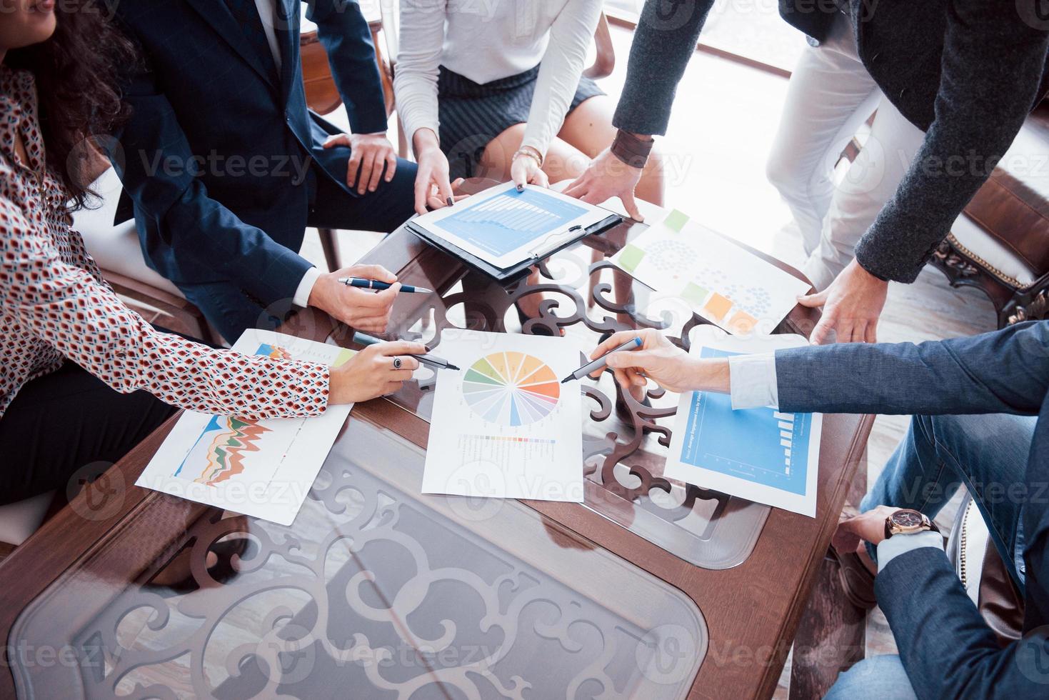 Brainstorming im Business-Team. Marketingplan recherchieren. Papierkram auf Tisch, Laptop und Handy foto