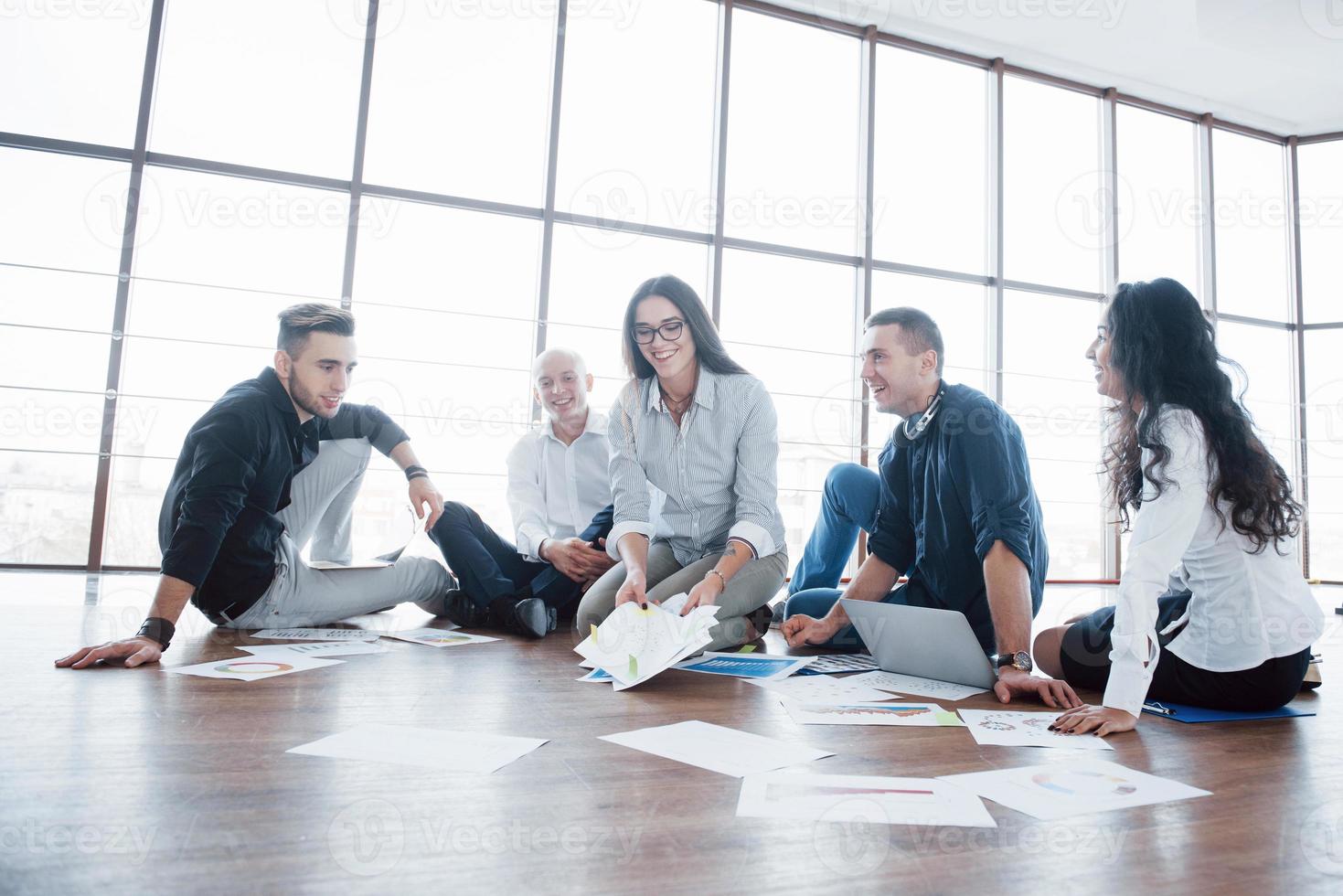 Planungsstrategie zusammen. Geschäftsteam, das sich Papiere auf dem Boden ansieht, wobei der Manager auf eine Idee hinweist. Zusammenarbeit Unternehmenserfolg. Planung Design zeichnen. Teamwork-Konzept foto