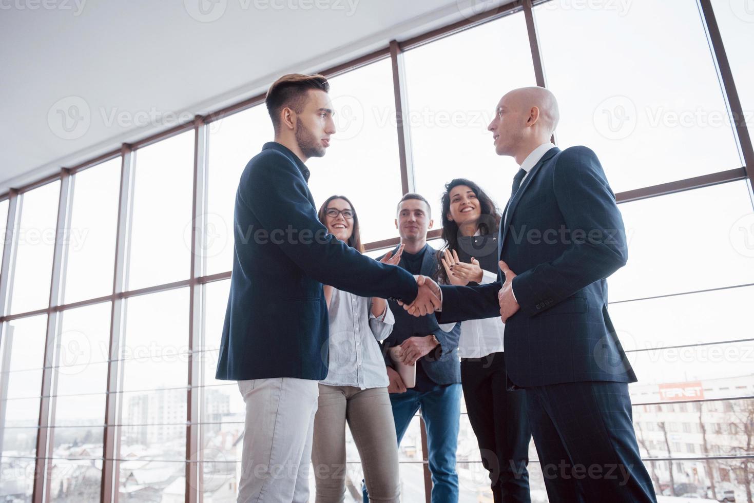 Zwei selbstbewusste Geschäftsleute, die sich während eines Meetings im Büro die Hände schütteln, Erfolg, Umgang, Begrüßung und Partnerkonzept foto