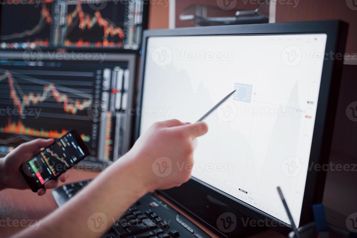 Daten analysieren. Nahaufnahme eines jungen Geschäftsmannes, der mit Stift auf die im Diagramm dargestellten Daten zeigt, während er im Kreativbüro arbeitet foto