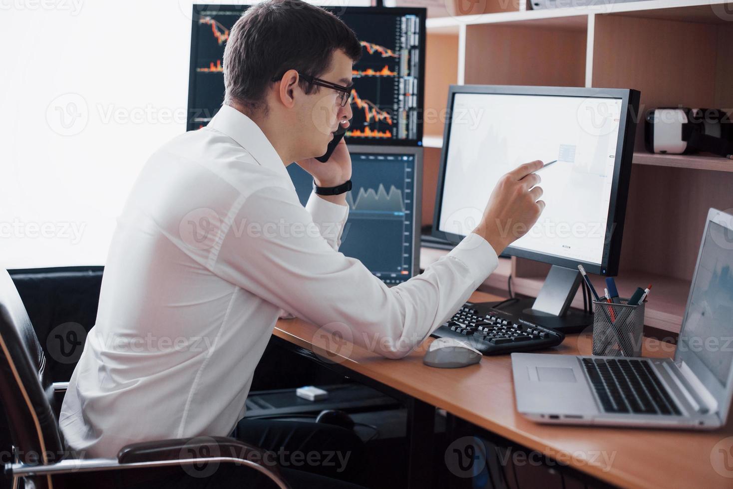 Börsenmakler im Hemd arbeitet in einem Überwachungsraum mit Bildschirmen. Börsenhandel Forex Finance Grafikkonzept. Geschäftsleute, die online mit Aktien handeln foto