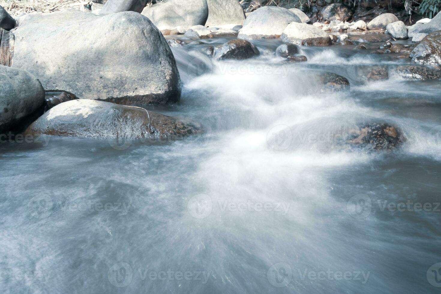 schließen oben von Wasser fließend Über Kopfsteinpflaster im Fluss foto