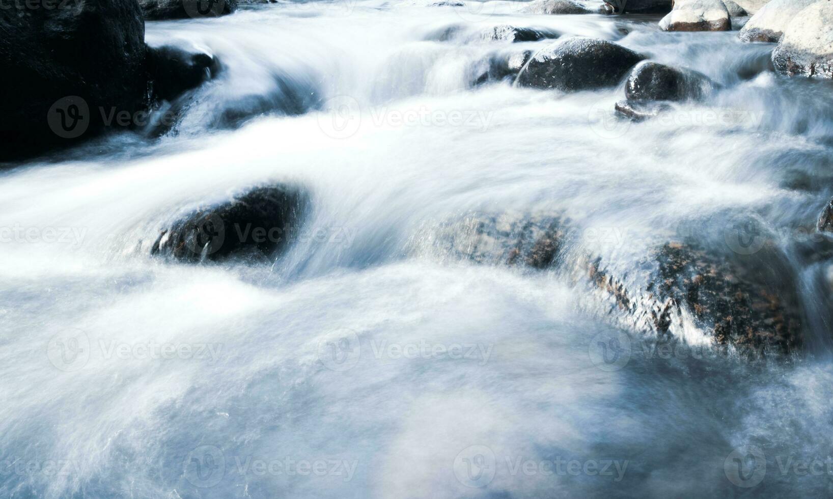 schließen oben von Wasser fließend Über Kopfsteinpflaster im Fluss foto