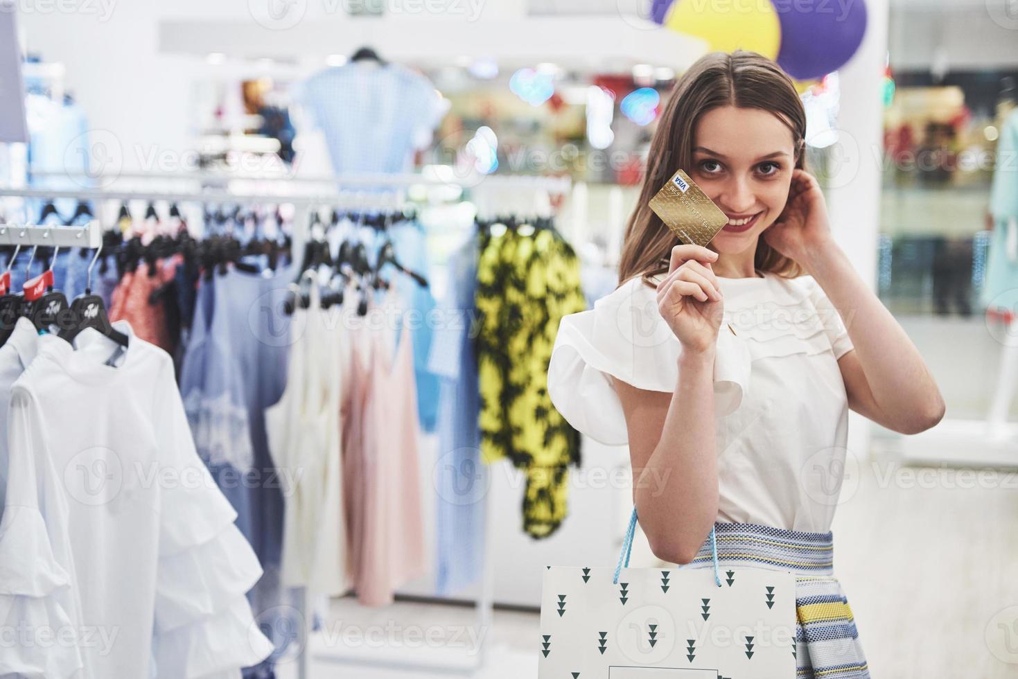 Frau beim Einkaufen. glückliche Frau mit Einkaufstüten und Kreditkarte beim Einkaufen. Konsum, Einkaufen, Lifestyle-Konzept foto