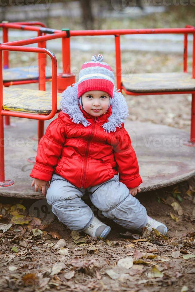 das Kind ist Spinnen auf ein schwingen im das Spielplatz im das Park foto