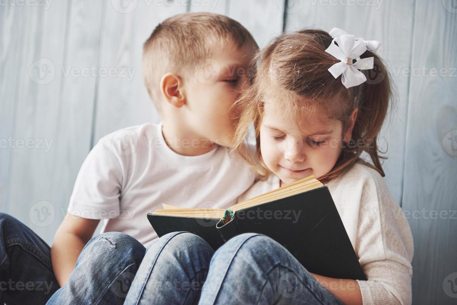 bereit für große Reisen. glückliches kleines Mädchen und Junge, die ein interessantes Buch lesen, das eine große Aktentasche trägt und lächelt. Reise-, Freiheits- und Vorstellungskonzept foto