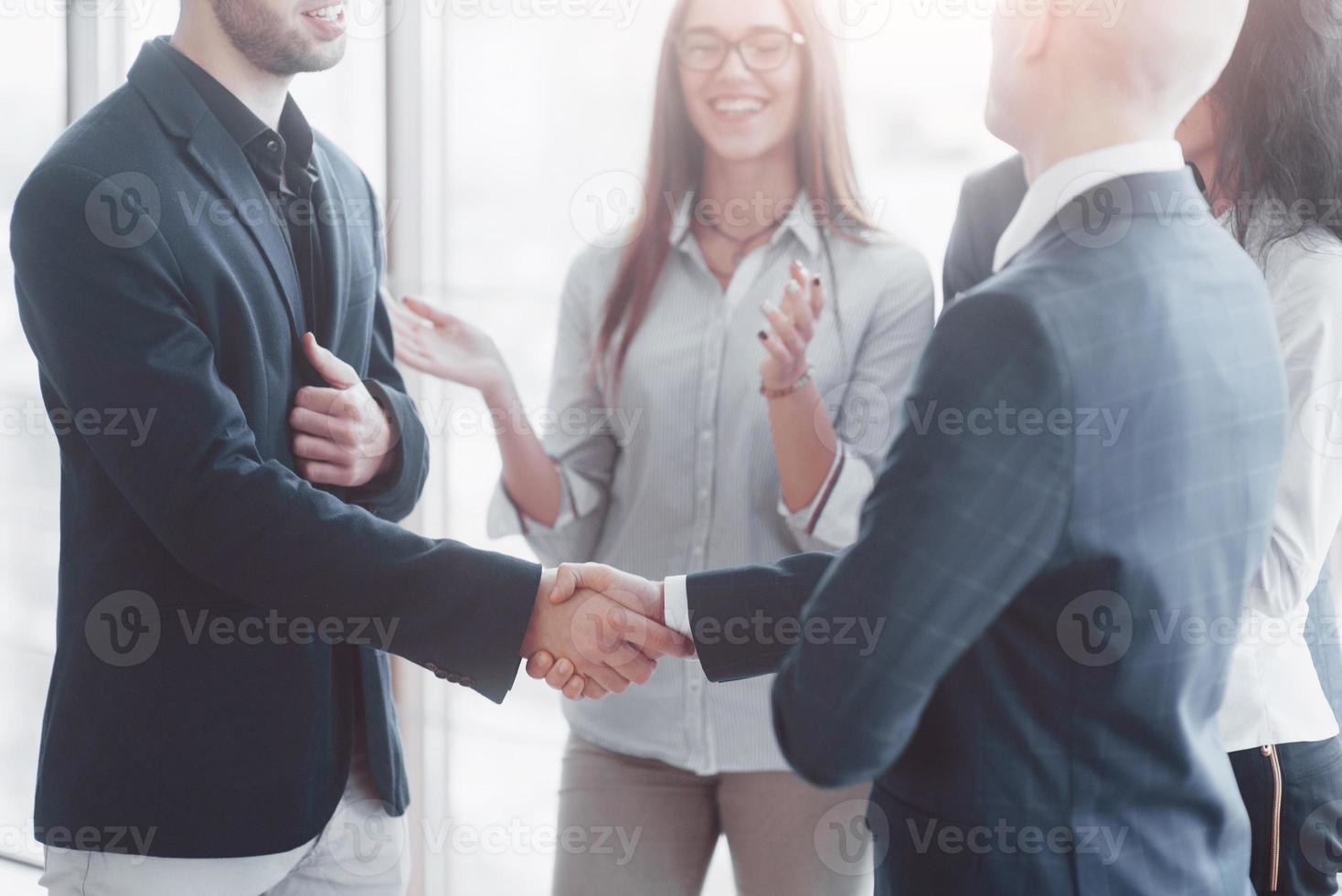 Zwei selbstbewusste Geschäftsleute, die sich während eines Meetings im Büro die Hände schütteln, Erfolg, Umgang, Begrüßung und Partnerkonzept foto