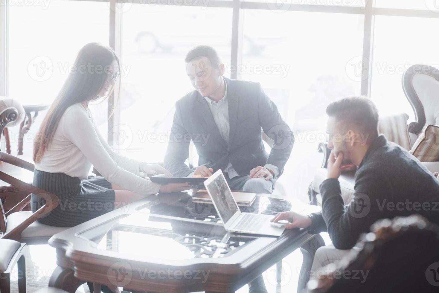 Junges Team von Mitarbeitern, die großartige Geschäftsgespräche im modernen Coworking-Büro führen. Teamwork-Menschen-Konzept foto