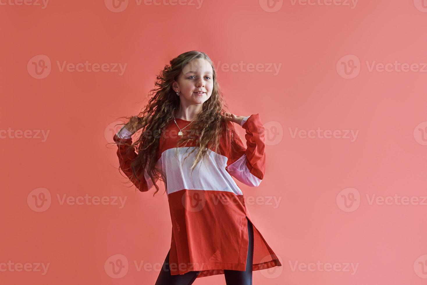 junge städtische Frau tanzt auf rotem Hintergrund, moderne schlanke Hip-Hop-Stil-Teenager-Mädchen foto