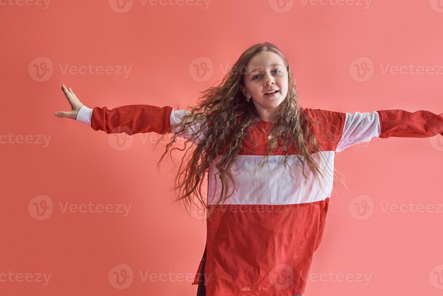 junge schöne süße Mädchen tanzen auf rotem Hintergrund, moderne schlanke Hip-Hop-Stil Teenager-Mädchen springen foto