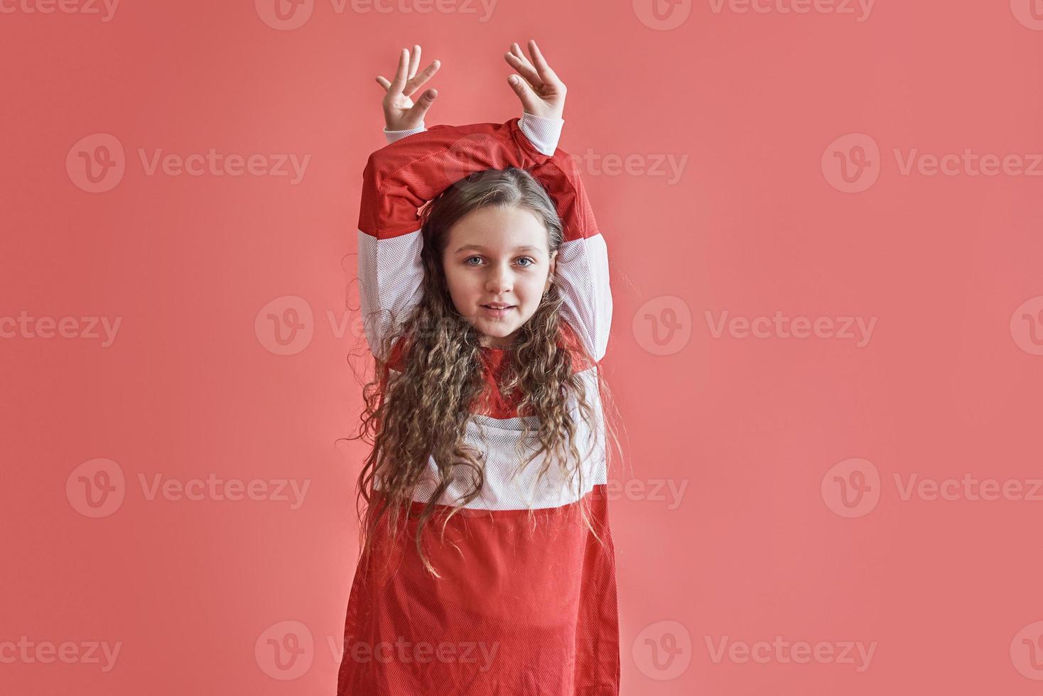 junge städtische Frau tanzt auf rotem Hintergrund, moderne schlanke Hip-Hop-Stil-Teenager-Mädchen foto