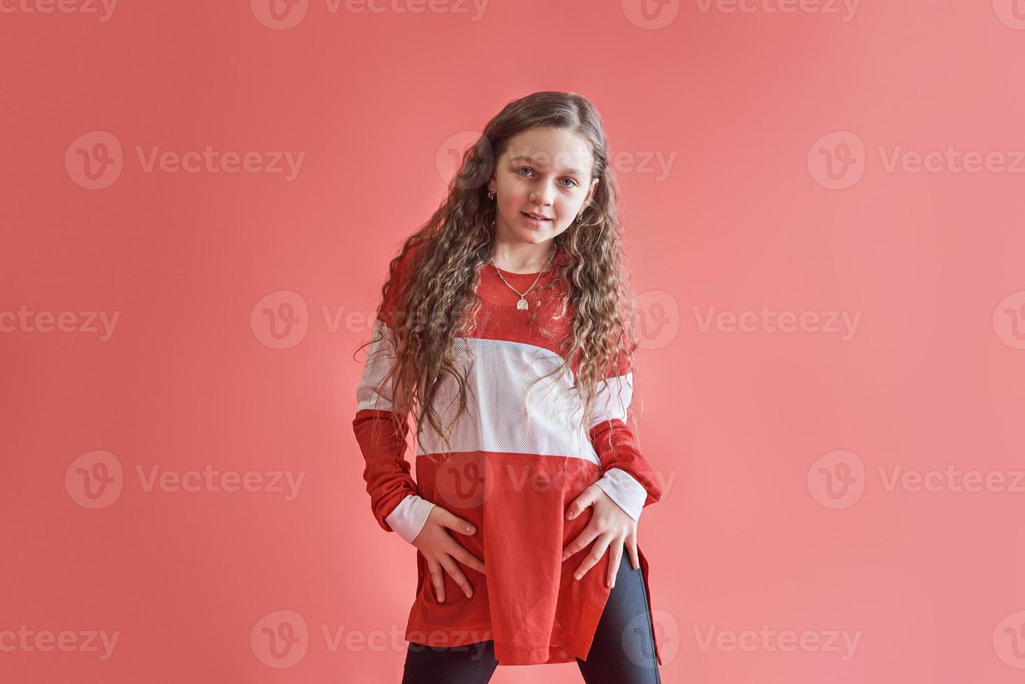 junge städtische Frau tanzt auf rotem Hintergrund, moderne schlanke Hip-Hop-Stil-Teenager-Mädchen foto