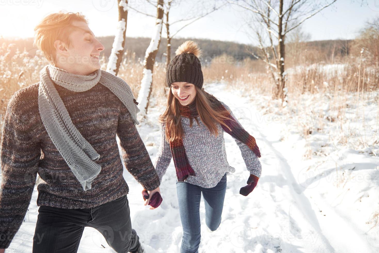 glückliches junges Paar im Winterpark, das Spaß hat. Familie im Freien foto