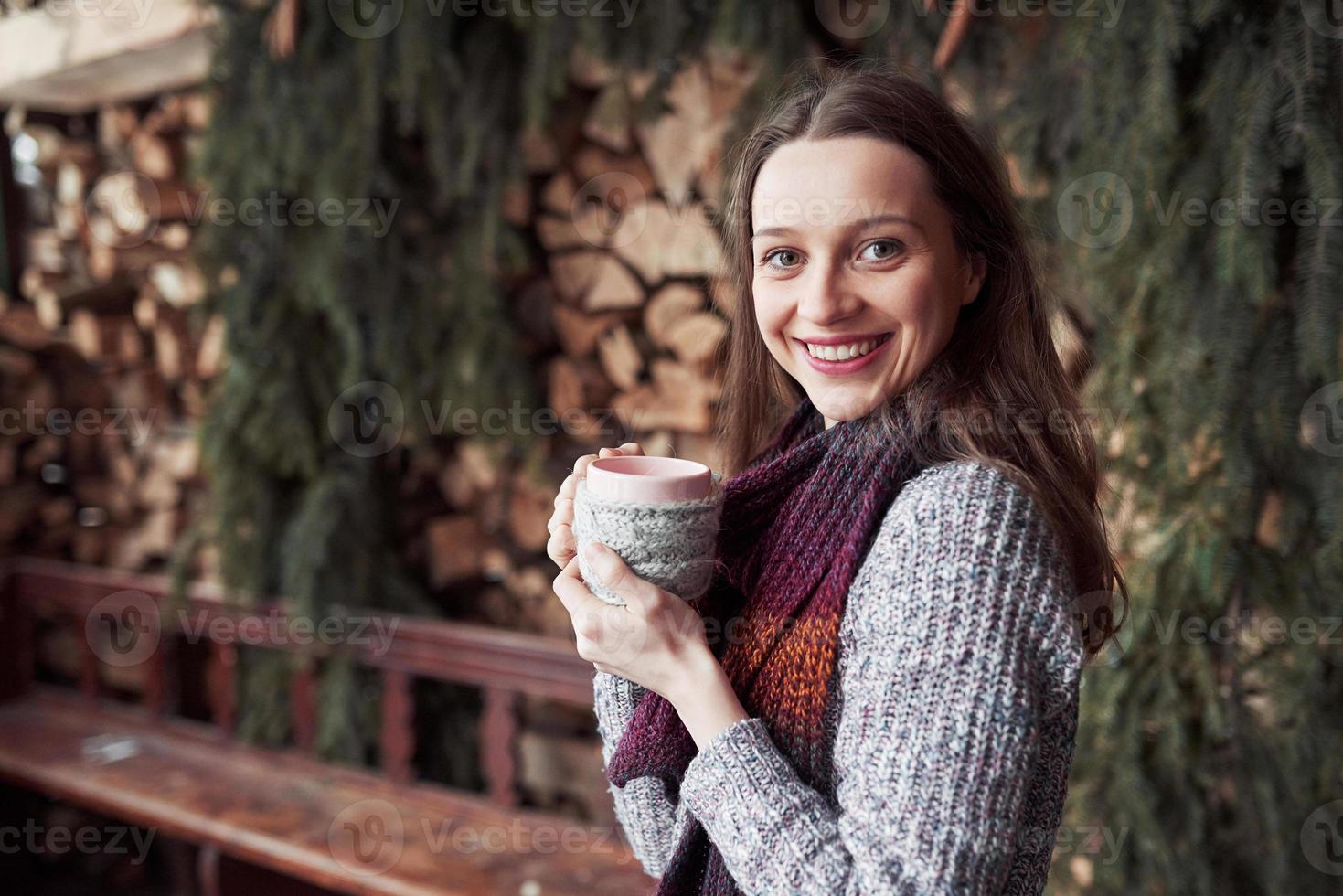 Oman trägt warme Strickkleidung und trinkt eine Tasse heißen Tee oder Kaffee im Freien foto