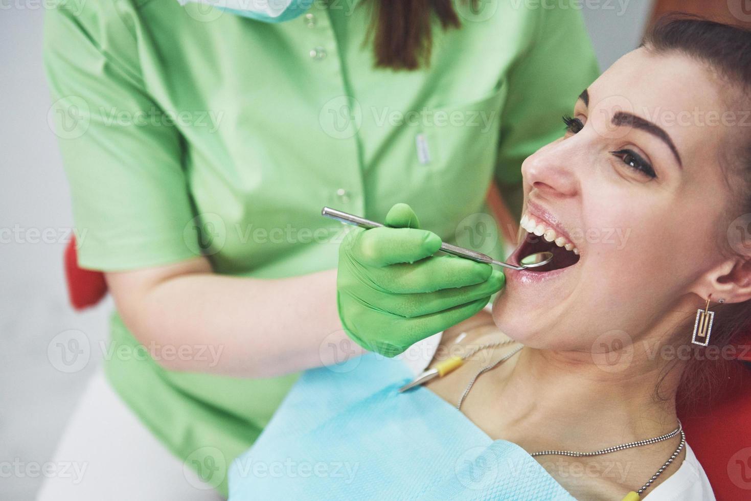 Zahnarzt, der eine Patientin in der Stomatologie kuriert. Frühpräventions- und Mundhygienekonzept foto