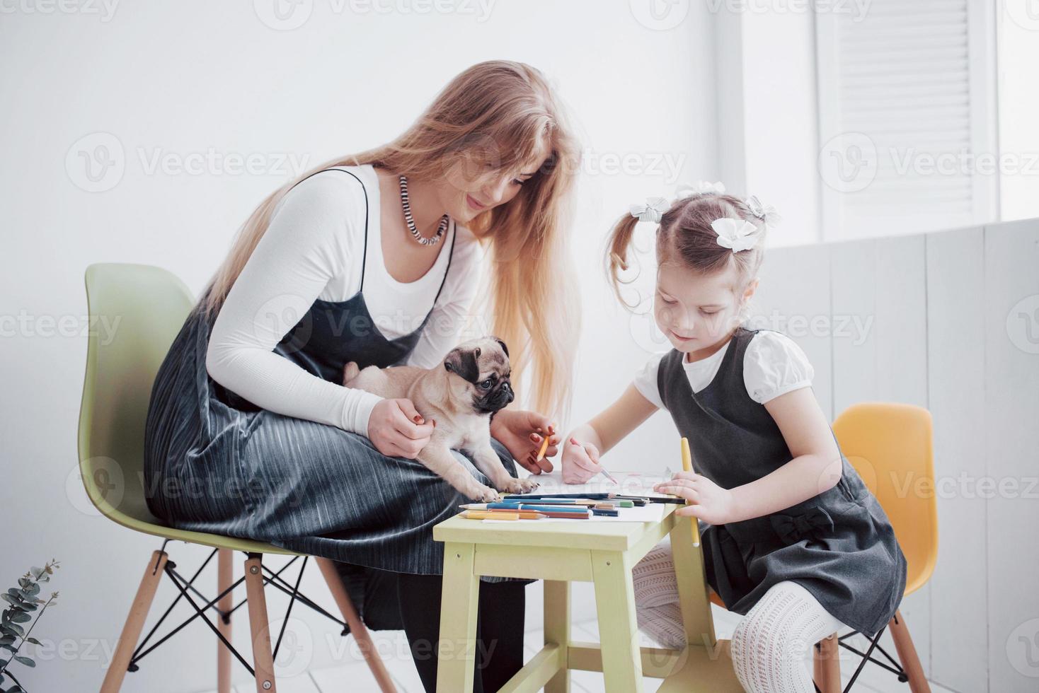 Mutter- und Kind-Tochter-Zeichnungen beschäftigen sich mit Kreativität im Kindergarten. kleiner Mops mit ihnen foto